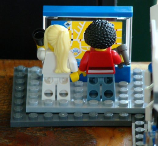 Annelise and Ife pretend to study the train schedule, but they're really thinking about their upcoming wedding.