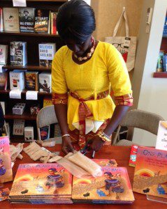Isatou Ceesay demonstrates how she cuts the plastic bag to make one continuous strand, first folding the bag and making straight cuts, leaving about an inch uncut at the end.